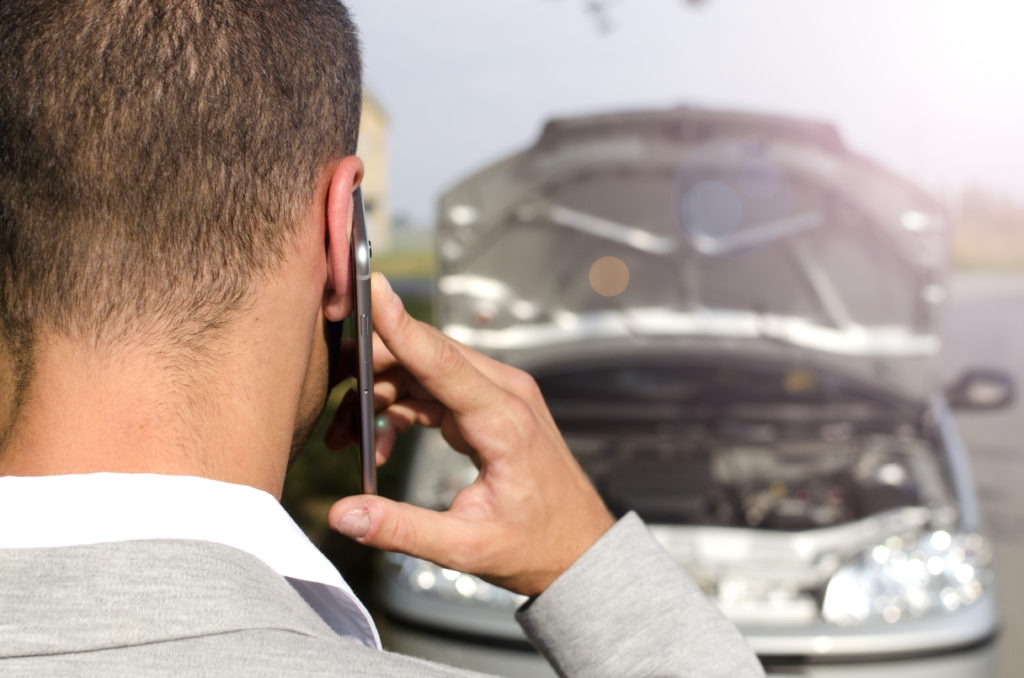 personne avec une voiture en panne contactant l'assistance