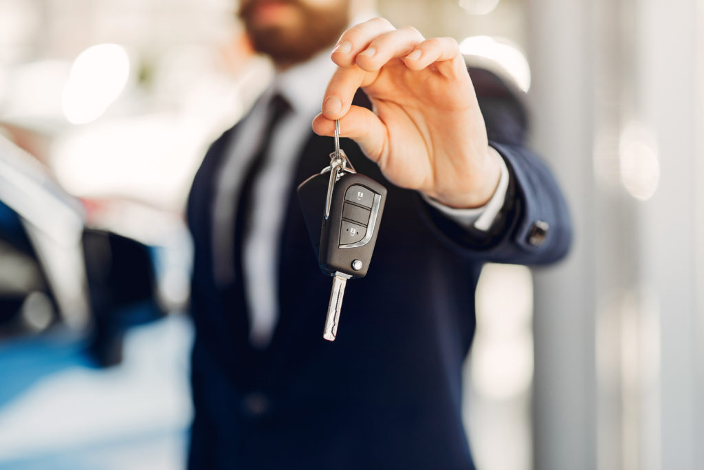 homme tendant les clés d'une voiture